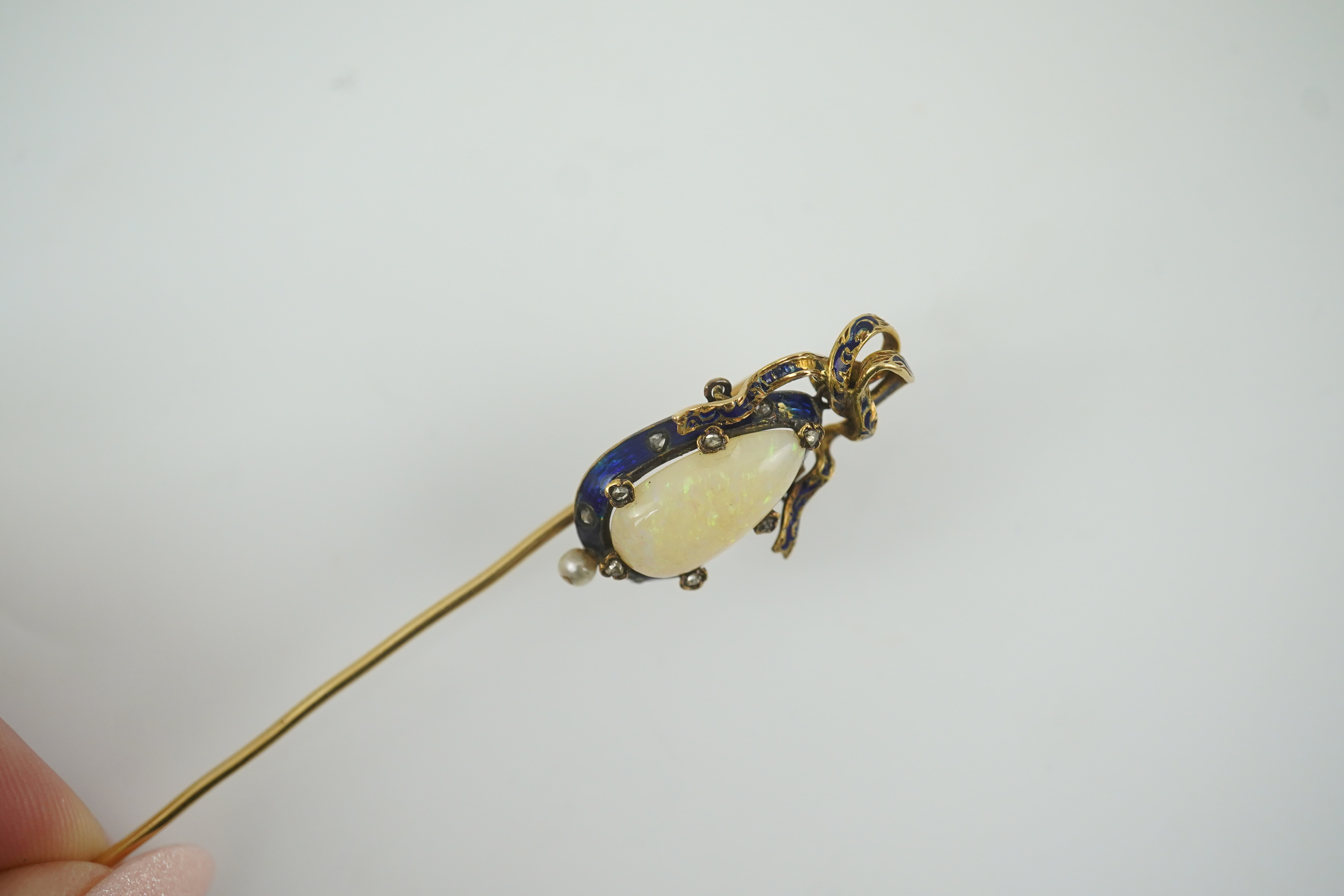 A late Victorian gold, white opal, seed pearl diamond chip and blue enamel set stick pin